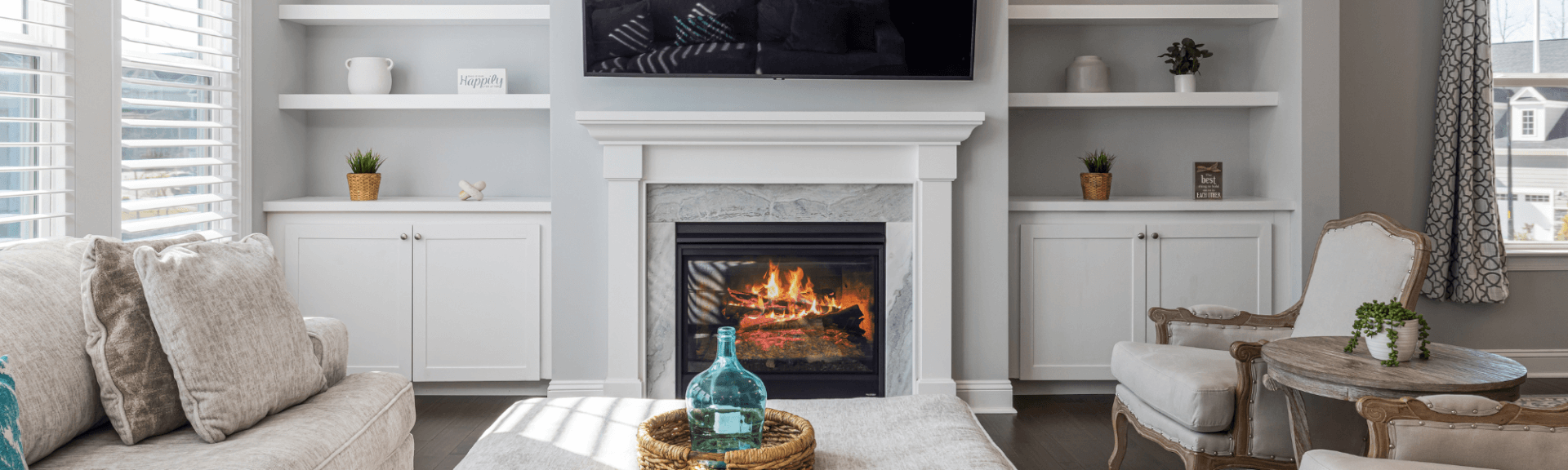 Interior image of living room with cozy furniture and a crackling fireplace.